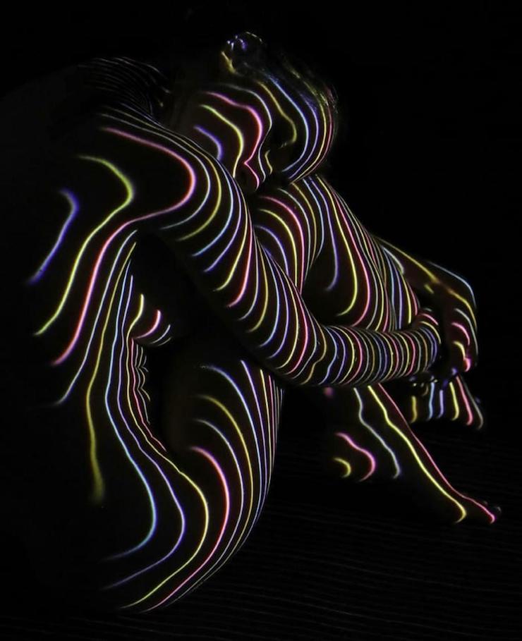 Un photographe habille des femmes dévêtues d’ombres et lumière colorée
