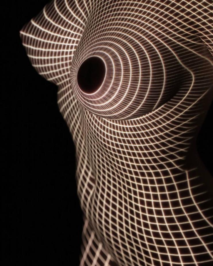 Un photographe habille des femmes dévêtues d’ombres et lumière colorée