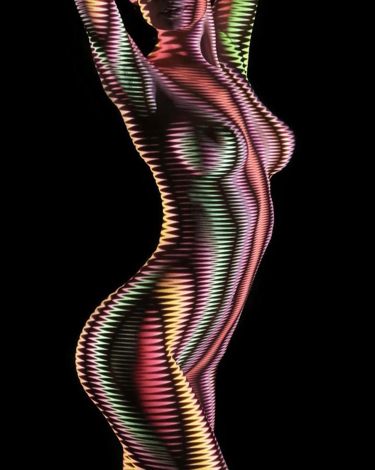 Un photographe habille des femmes dévêtues d’ombres et lumière colorée