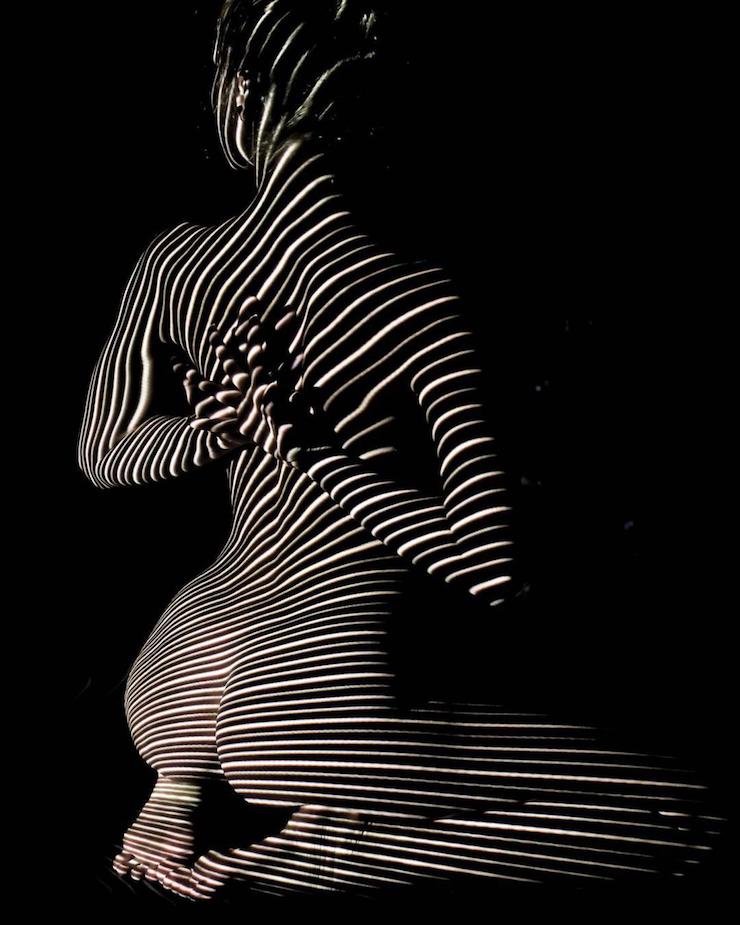 Un photographe habille des femmes dévêtues d’ombres et lumière colorée