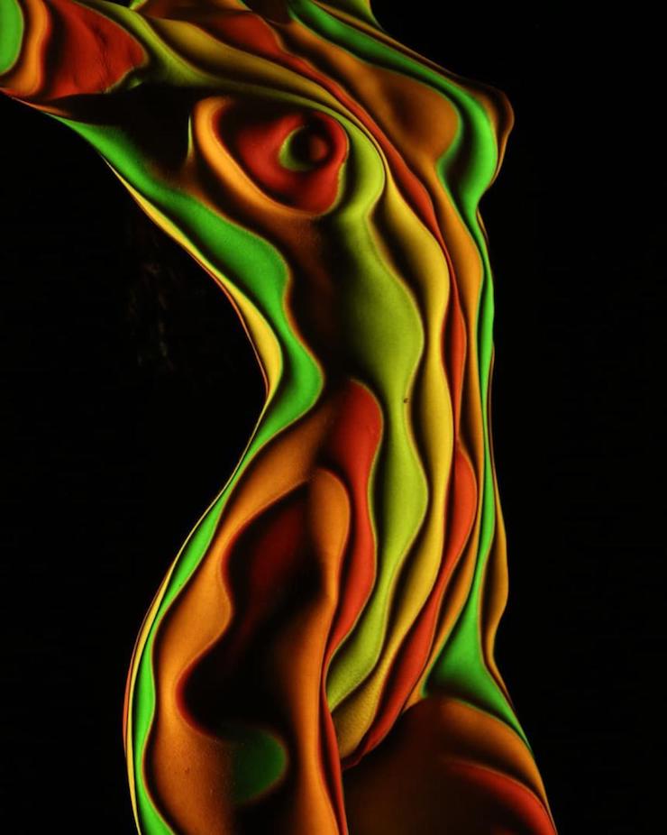 Un photographe habille des femmes dévêtues d’ombres et lumière colorée