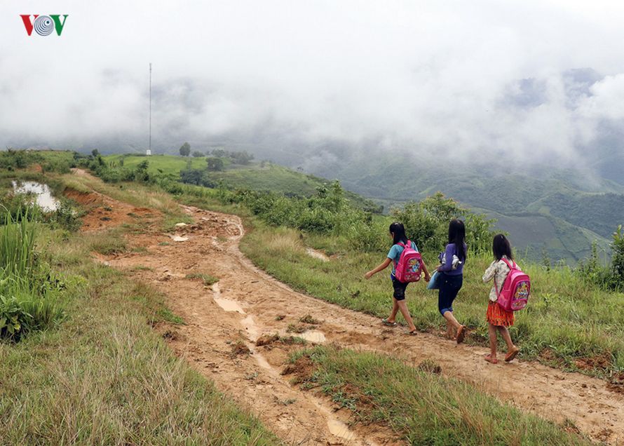 Des enfants dans un village au Vietnam traversent la rivière dans des sacs en plastique pour aller à l’école