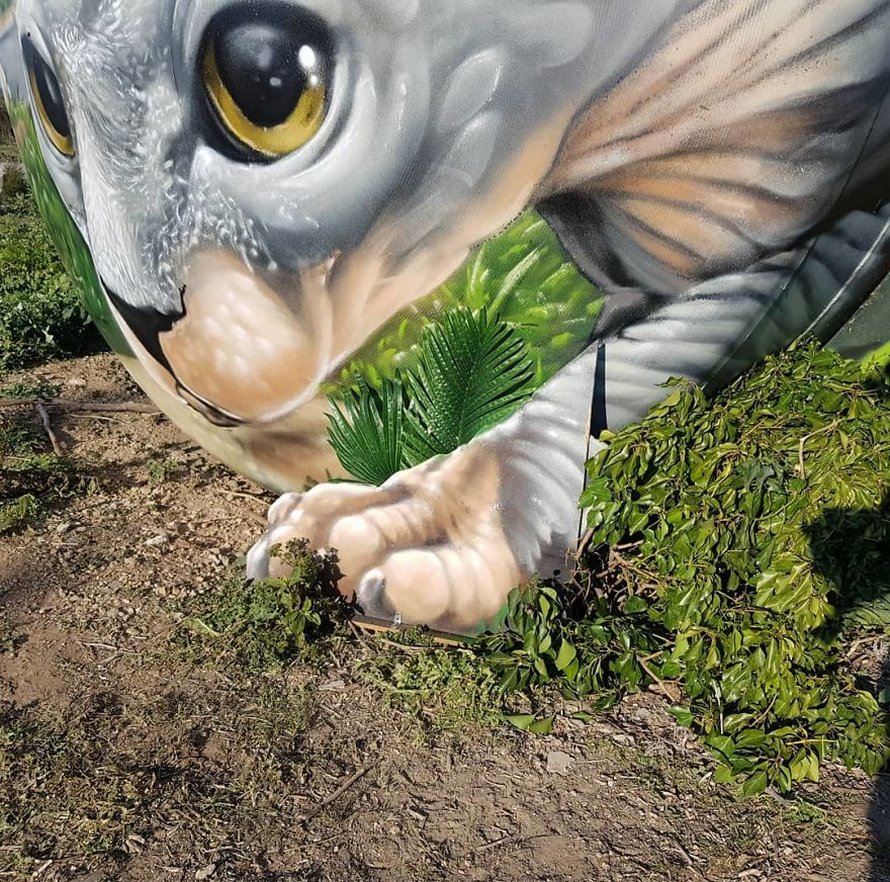 Un artiste de rue peint une illusion bluffante d’un chat sphynx sur un vieux réservoir d’essence