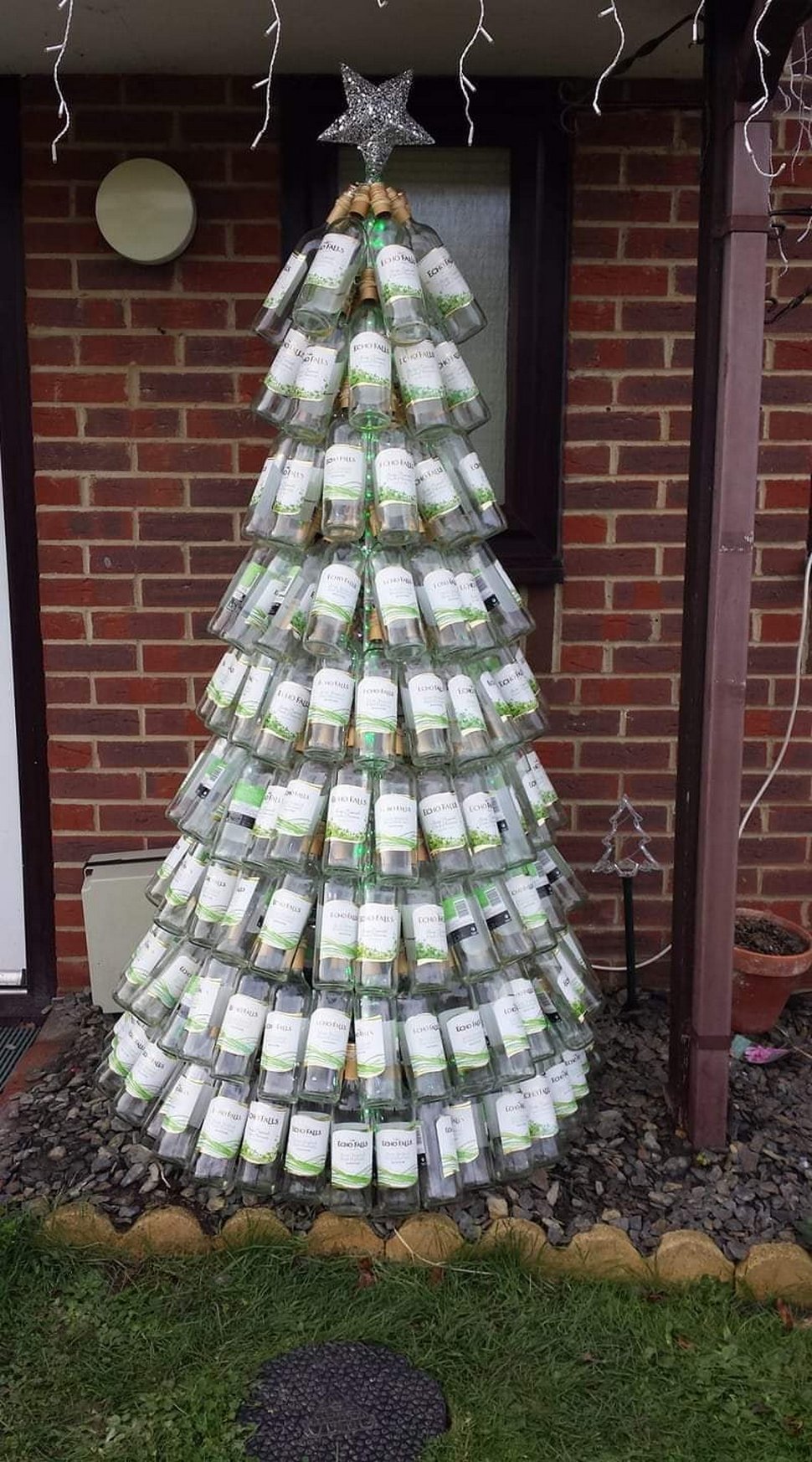 Une maman présente son sapin de Noël fait entièrement de bouteilles de vin vides