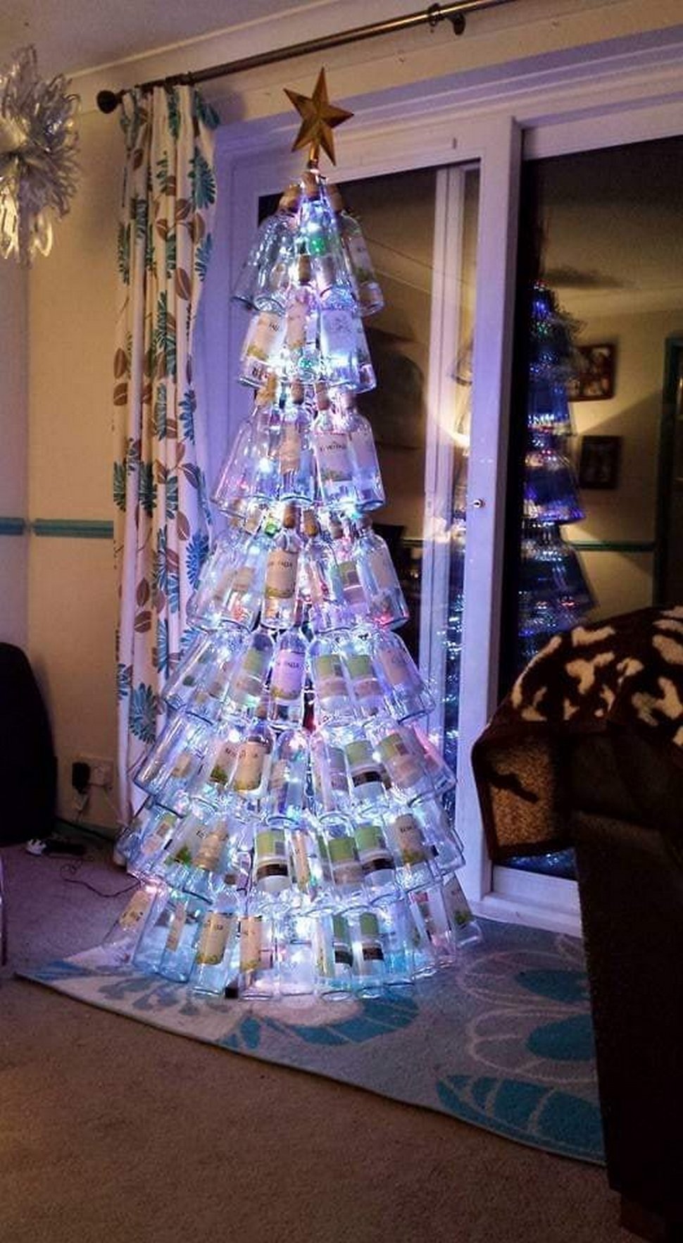 Une maman présente son sapin de Noël fait entièrement de bouteilles de vin vides