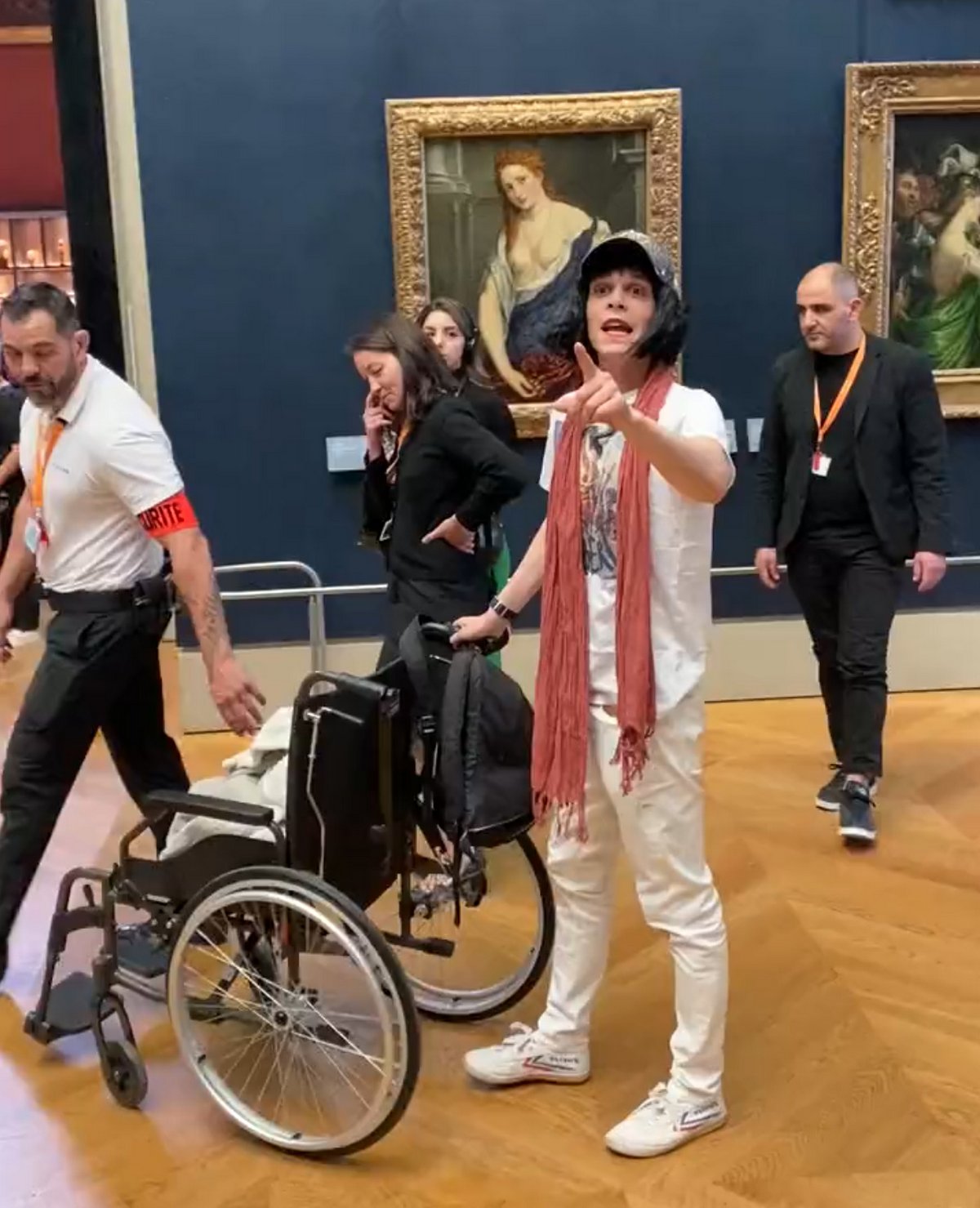 Un homme déguisé en vieille femme en fauteuil roulant enduit la Joconde de gâteau au Louvre